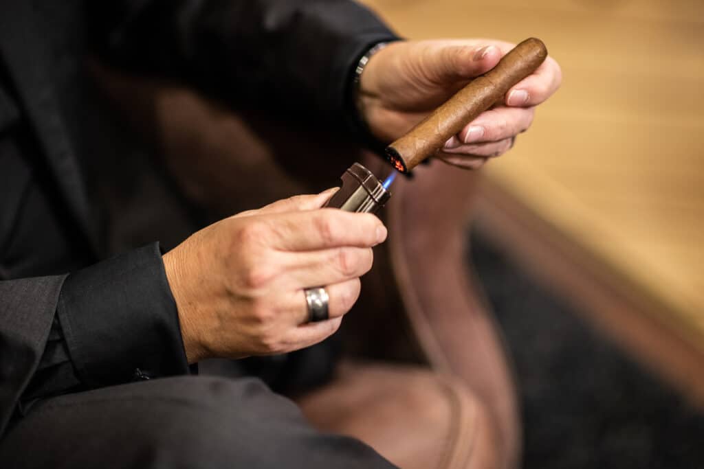 Man in suit lighting a cigar