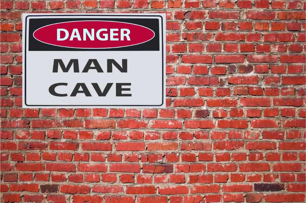 sign danger man cave on red brick wall