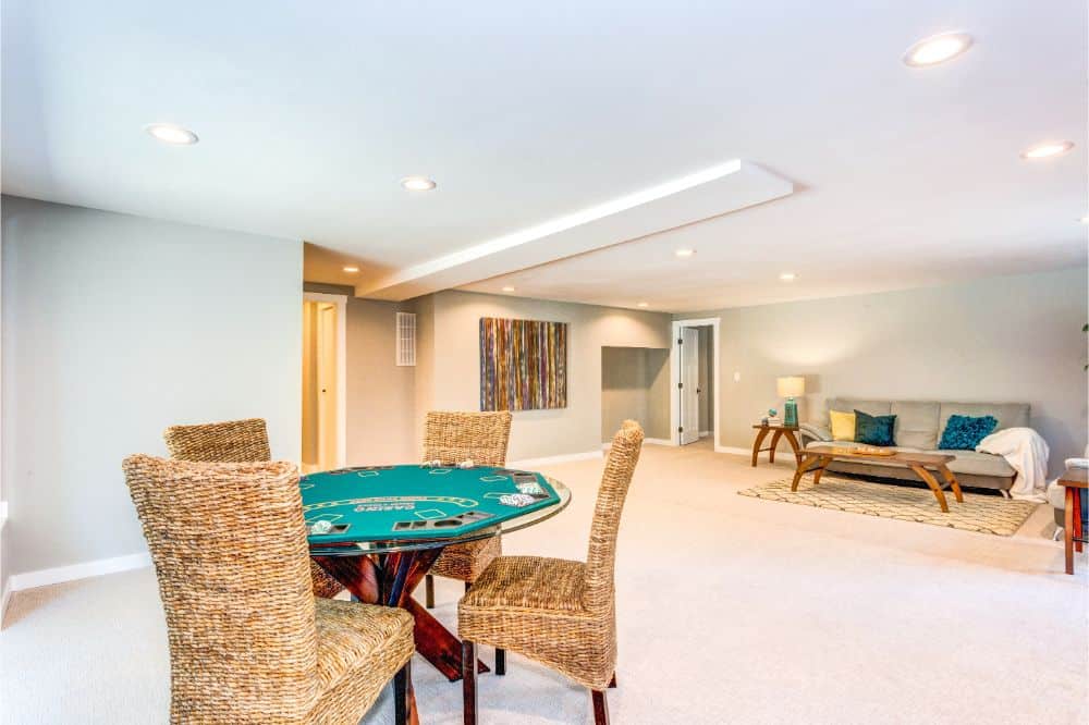 poker table and couch in basement