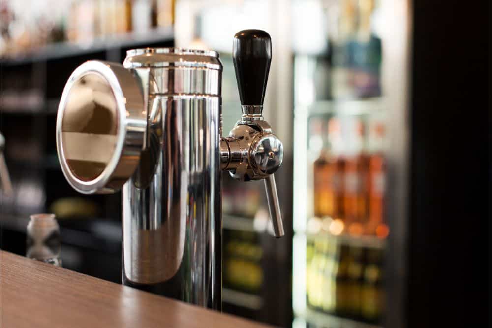 Close up of a male bartender dispensing draft beer